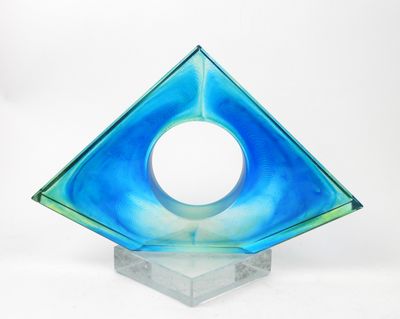 une sculpture en verre bleu percée d'un trou circulaire au milieu