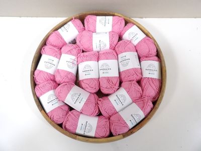 many balls of pink yarn in a bowl on a table