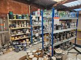 many cans of paint on the shelves in the room