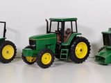 three toy tractors that are sitting next to each other