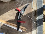 a pair of pliers on the ground next to a piece of wood