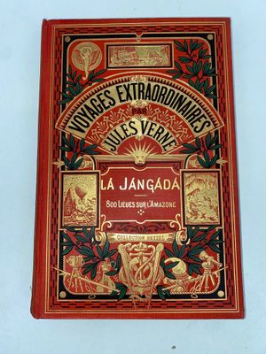 an old book on a white table with a red cover