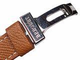 the brown leather strap has a silver buckle on it