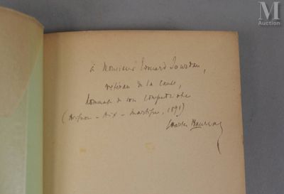 un livre ouvert, sur lequel est inscrit un poème manuscrit, posé sur une table