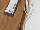 un gros plan sur un pantalon marron muni d'une étiquette
