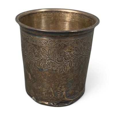 a metal cup that is sitting on a white surface