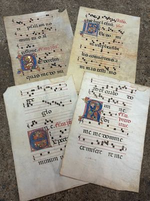 trois vieux manuscrits portant des inscriptions, posés par terre