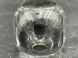 a small glass object with a face inside of it