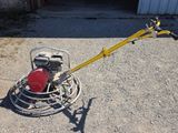 a close up of a machine on the ground near a building