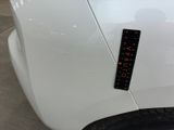 a close up of a white car with a sticker on it