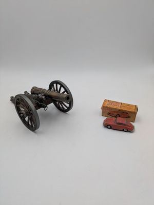 a toy car and a toy cannon on a white surface