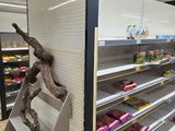 a statue of a man that is standing on a shelf in a store