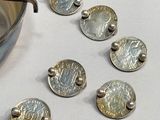 some coins are sitting on a table next to a pot