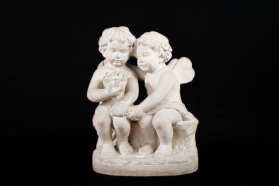 a white statue of two children sitting on a bench