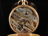 a gold pocket watch that is sitting on a table