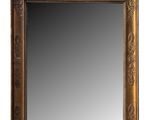 a gold framed mirror on a white wall with a white background