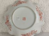 a white plate with red flowers on it on a table