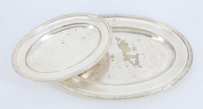 paire de plats plaqués argent avec couvercles, posés sur un plan de travail blanc