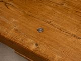 a close up of a wooden table with a metal button on it