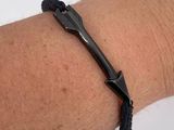 a man ' s arm with a black bracelet with a black anchor on it
