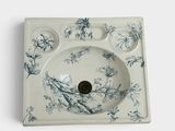 un évier blanc orné d'un motif floral bleu et blanc
