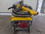 a small yellow machine with a hose on top of it