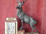 statue of a stag on a marble base with a clock on it