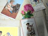 de nombreuses cartes et cartes postales par terre, à côté d'un chat