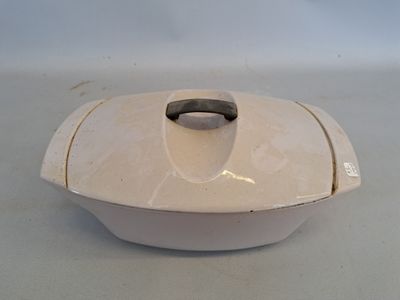 un plat à gratin blanc avec un couvercle posé sur une table
