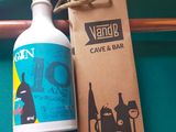 a bottle of liquid next to a bottle of wine on a table