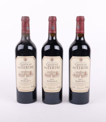 trois bouteilles de vin rouge posées l'une à côté de l'autre sur une surface blanche