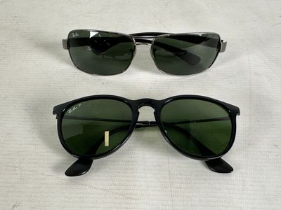 two pairs of ray bans with green lenses on a white surface
