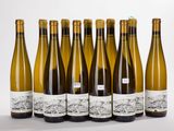 six bottles of wine are lined up in a row on a white surface