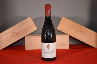 a bottle of wine sitting on a table next to two wooden boxes