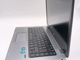 a silver laptop with a black keyboard on a white surface