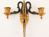 a wall sconce with two candle holders attached to it