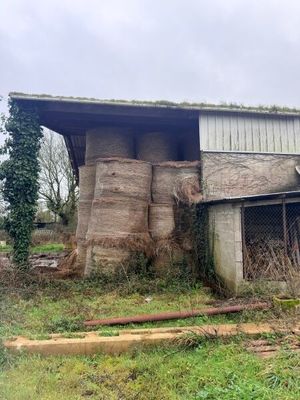 une image représentant une grange sur laquelle est empilé du foin