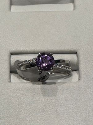une photo d'une bague en diamant violette dans un écrin blanc