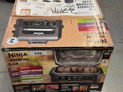 packaging of a box with a grill inside of it sitting on a floor