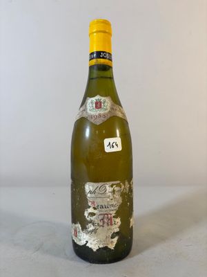 une vieille bouteille de vin posée sur une table blanche