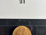 a close up of a gold coin on a black surface