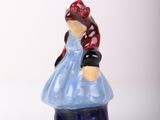a small figurine of a woman in a blue dress