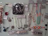 many different types of necklaces and bracelets hanging on the wall