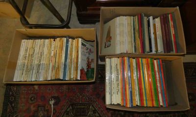 une boîte remplie de livres posée par terre à côté d'une table