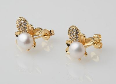 a pair of earrings with pearls and diamonds on a white background