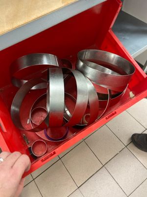 a person opening a red box with a bunch of pans inside of it