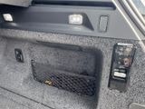 the interior of a car with the door open and a phone in the trunk
