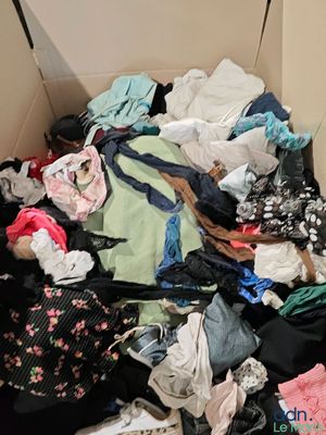 une boîte pleine de vêtements posée sur le sol