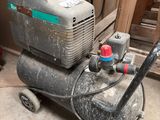 a small air compressor sitting on the floor in the garage