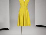 une photo d'une robe jaune sur un présentoir à mannequin